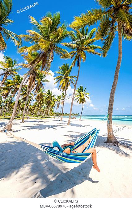 Canto de la Playa, Saona Island, East National Park (Parque Nacional del Este), Dominican Republic, Caribbean Sea. Woman relaxing on a hammock on the beach (MR)