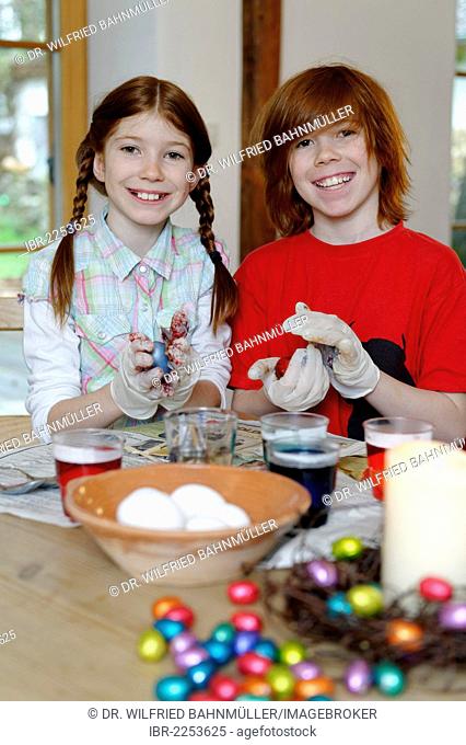 Boy and girl coloring Easter eggs, painting Easter eggs