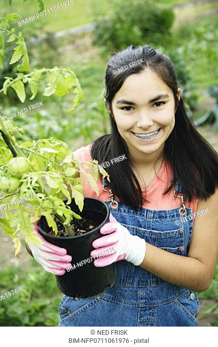 Girl holding tomato plant