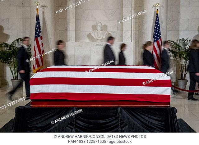 People walk past the late Supreme Court Justice John Paul Stevens as he lies in repose in the Great Hall of the Supreme Court in Washington, Monday, July 22