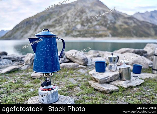 Coffee pot on gas stove burner by lake, Splugen Pass, Sondrio, Italy