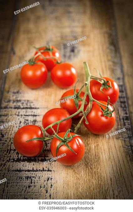 Fresh cherry tomatoes on wooden background, France