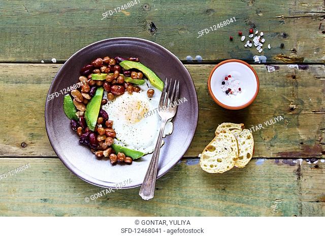 An English breakfast with baked beans, fried eggs and avocado