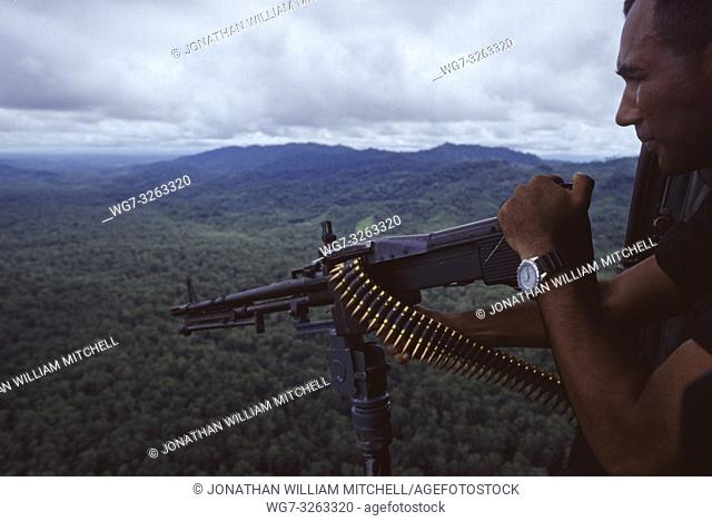 PANAMA Darien Gap -- 10 Jul 1997 -- A Panamanian frontier policeman mans an M-60 light machine gun about a helicopter over the jungles of the Darien Gap of...