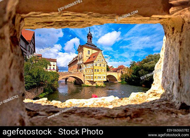 Bamberg. Scenic view of Old Town Hall of Bamberg (Altes Rathaus) with two bridges over the Regnitz river view through stone window, Bavaria region of Germany