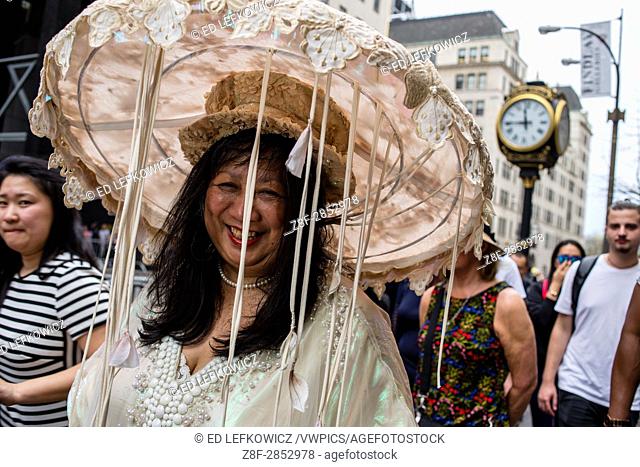 New York, NY - April 16, 2017. A woman in a large and elaborate hat bedecked in lace and with festoons of ribbons at New York's annual Easter Bonnet Parade and...