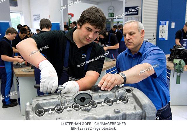 Master explaining to an apprentice while working on an engine in the BMW training center for automotive mechatronics, Munich, Bavaria, Germany, Europe