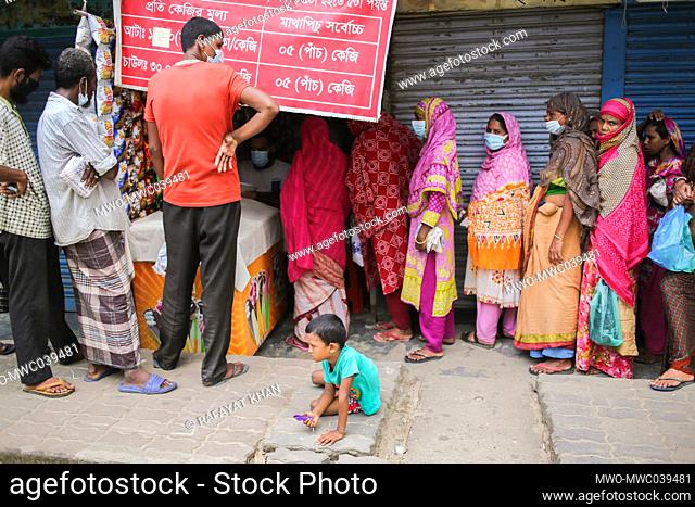 Women are waiting in a queue to buy Rice and Flour from the open market sale (OMS) dealers in Modu Shohid, Sylhet, Bangladesh.Â