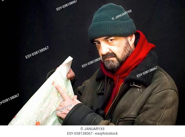 Portrait of adventure man with map and extreme explorer gear over black background