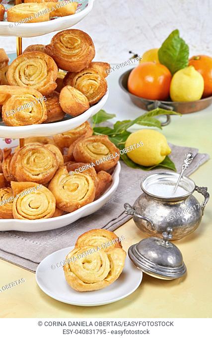Closeup of Italian pinwheel orange pastries, typical sweets made during the carnival period from fried puff pastry flavored with orange zest and honey