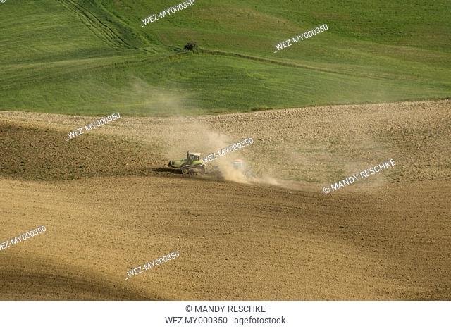 Italy, Tuscany, Crete Senesi, Tractor on field