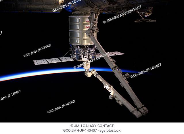 Intersecting the thin line of Earth's atmosphere, the Orbital Sciences' Cygnus cargo craft attached to the end of the Canadarm2 robotic arm is berthed to the...