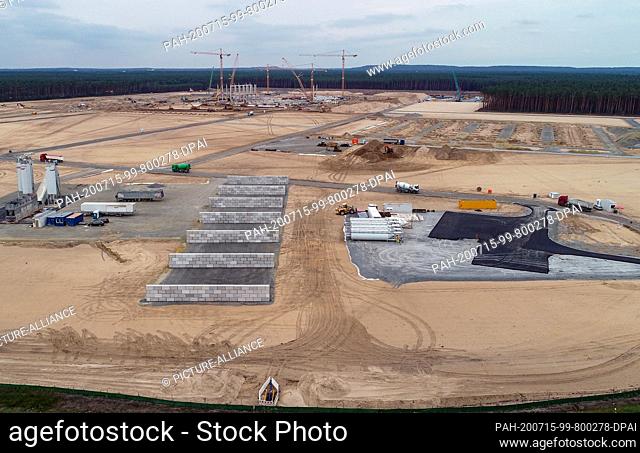 15 July 2020, Brandenburg, Grünheide: Cranes and first piers for the future Tesla Giga-Factory can be seen on the construction site (aerial view with a drone)