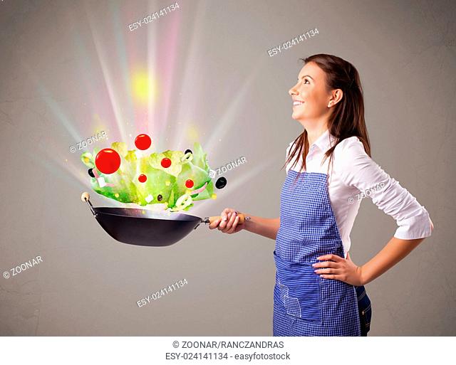 Young woman cooking fresh vegetables