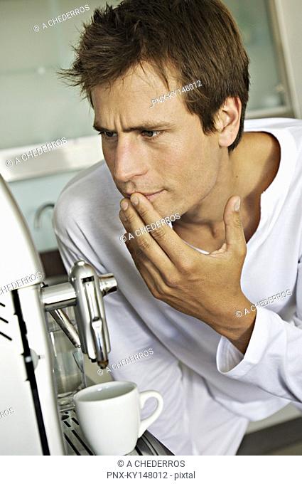 Young man in front of espresso maker
