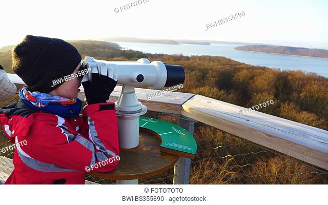 child glassing through a coin telescope the Kleiner Jasmunder Bodden , Germany, Mecklenburg-Western Pomerania, Ruegen, Prora