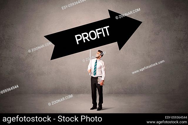 Young business person in casual holding road sign with PROFIT inscription, business direction concept