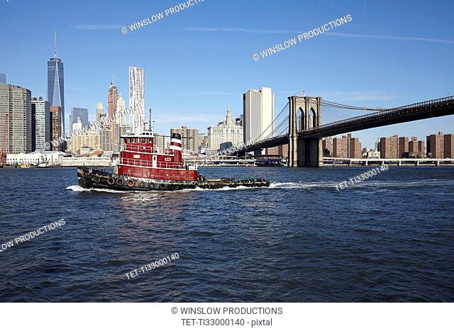 View of boat, Brooklyn bridge and cityscape