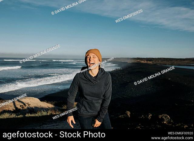 Happy woman enjoying at volcanic beach, Janubio Beach, Lanzarote, Canary Islands, Spain