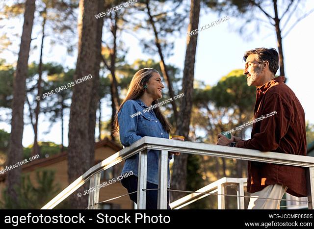 Mature couple talking at railing in nature