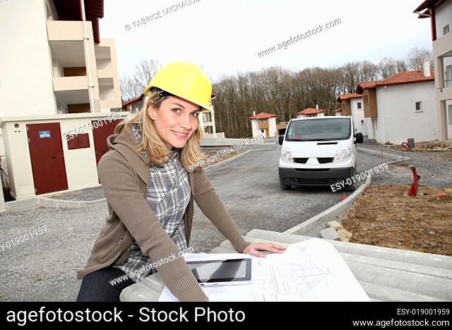 Woman engineer looking at plan on construction site