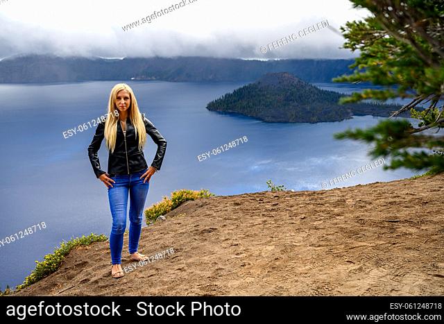 Long haired blonde posing for a photo in the extreme weather over Crater Lake, Oregon, United States of America