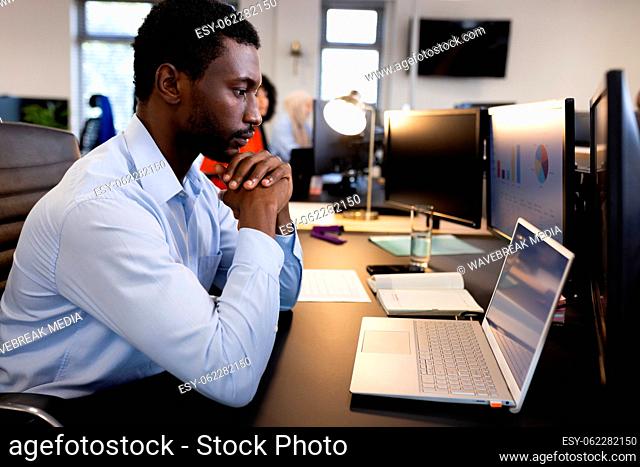 African american man working on laptop in office
