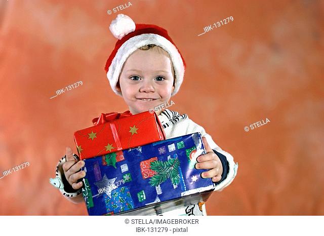 A lucky young boy with Christmas presents
