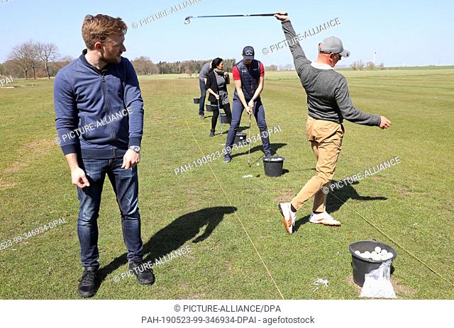 19 April 2019, Mecklenburg-Western Pomerania, Ribnitz-Damgarten: Golf instructor Tom Siegfried (r) with Philipp Braun (l-r), Robert van der Wal
