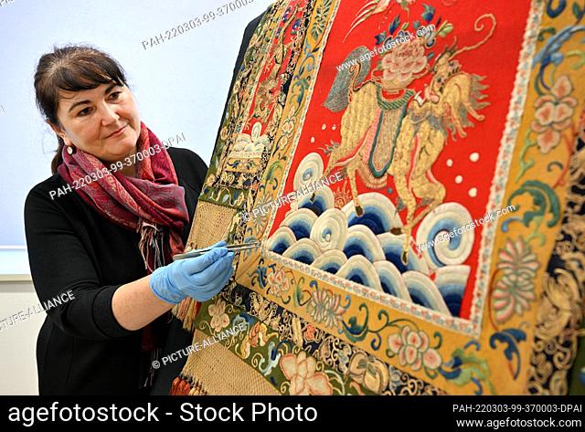 03 March 2022, Thuringia, Gotha: Marie-Luise Gothe, textile restorer, looks at a saddle blanket that Prince Raden Saleh of Java once gave as a gift to Duke...