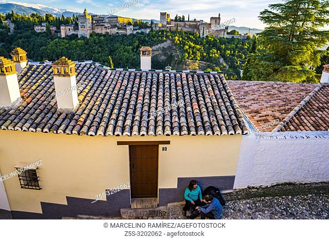 Narrow street in the Sacromonte - Albaicin, in the background, sunset over the Alhambra. Granada, Andalucia, Spain, Europe