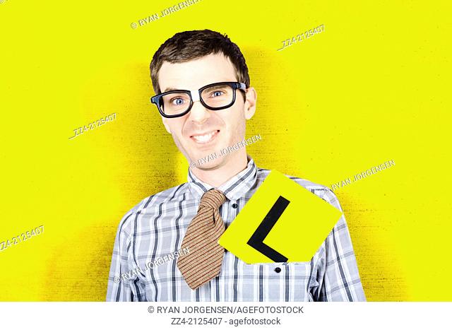 Humorous image of a dorky businessman wearing learner driving plate when attending first day at work. New recruit