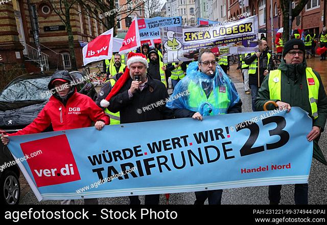 dpatop - 21 December 2023, Schleswig-Holstein, Kiel: Participants in a warning strike march with Verdi union flags and a banner reading ""Dignity