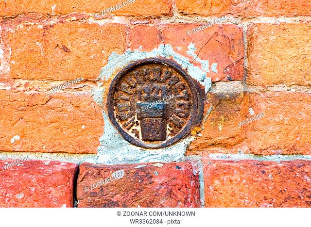 Vintage Russian government survey marker (benchmark disk) in the wall of building