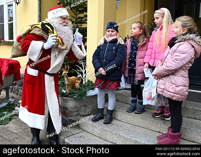 12 November 2020, Brandenburg, Himmelpfort: Children from the primary school welcome Santa Claus to Himmelpfort. Until Christmas Eve he will answer the...