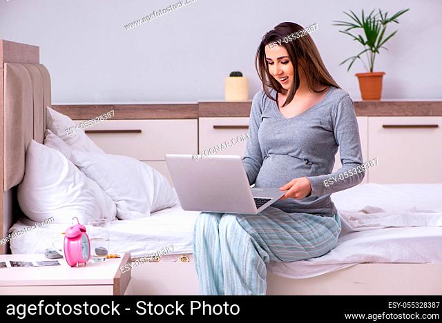 The young pregnant woman in the bedroom