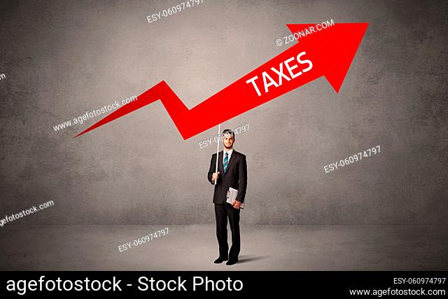 Young business person in casual holding road sign with TAXES inscription, business direction concept