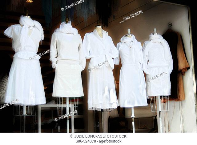 Women's white summer clothing displayed in a retail store window