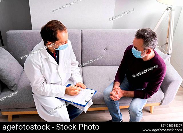 Doctor Talking To Senior Patient Older Man At Home