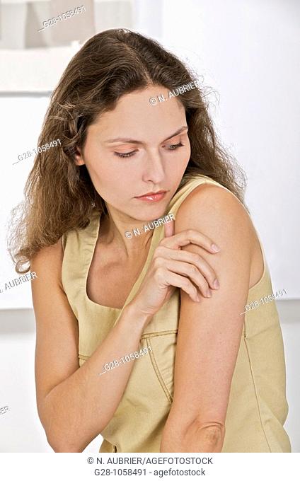 young woman scratching her arm  because of an itching sensation