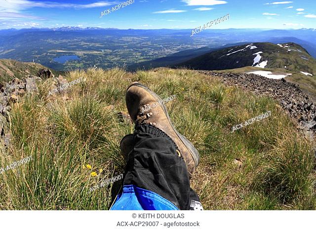 Wide angle view of hikers boots in alpine area overlooking the Bulkley Valley, Smithers, British Columbia