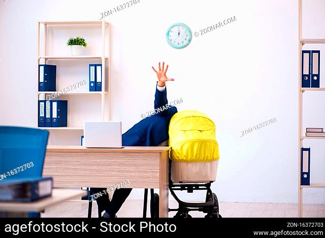Young employee looking after kid at workplace