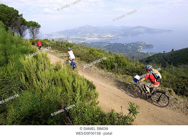 Italy, Tuscany, Elba, Mountainbikers riding across coastal path