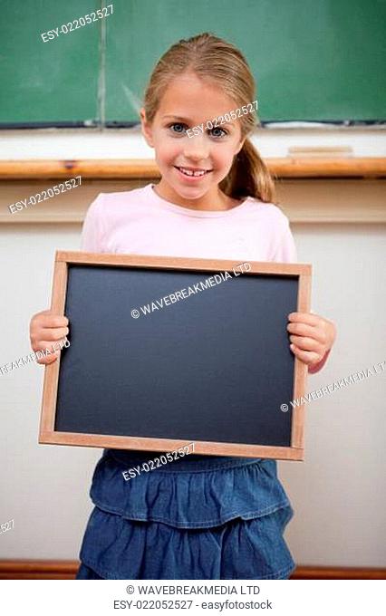 Portrait of a young girl holding at a school slate