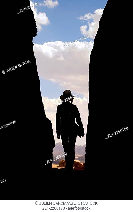 Silhouette of a woman with a hat in a narrow canyon. Jordan, Wadi Rum desert, protected area inscribed on UNESCO World Heritage list. Model Released