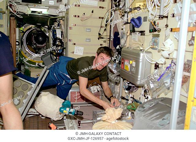 Cosmonaut Sergei K. Krikalev, Expedition One flight engineer, retrieves a tool during an installation and set-up session in the Zvezda service module aboard the...