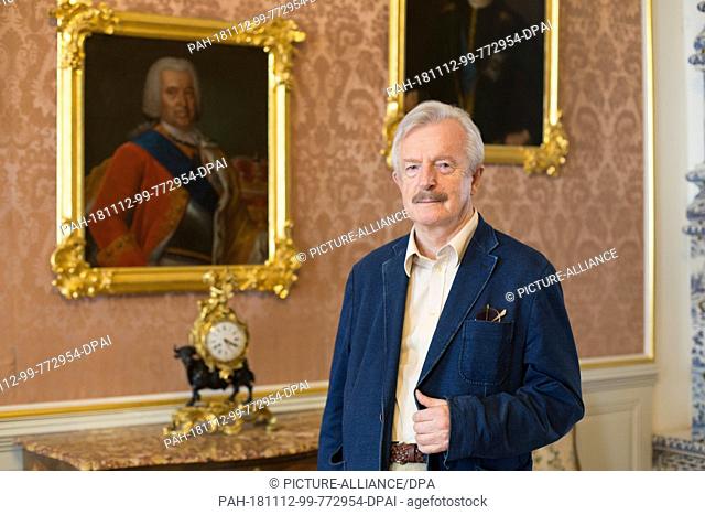 26 August 2018, Latvia, Rundale: The art historian and long-time director of the palace, Imants Lancmanis, stands in front of a portrait of the Duke of Kurland