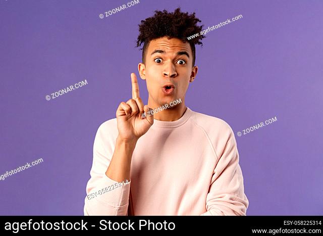 Got it, have plan. Portrait of excited happy young man, rejoicing as being striked with great idea, raise index finger in eureka gesture, figured out something
