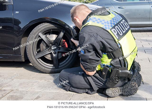 ATTENTION: EMBARGOED FOR PUBLICATION UNTIL 16 OCTOBER 17:00 GMT! - 16 October 2018, Lower Saxony, Melle: A policeman documents a lowered Golf GTI during a major...