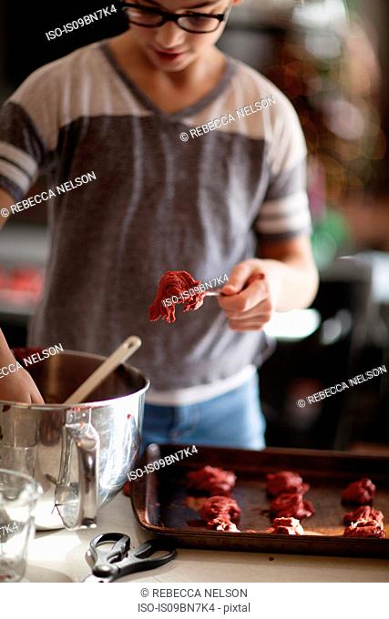 Girl putting christmas cookie dough on baking tray